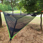 Triangle camping hammock installed between trees for outdoor relaxation and camping