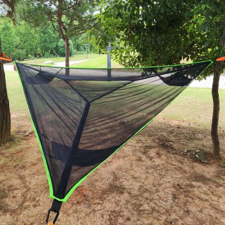 Triangle camping hammock installed between trees for outdoor relaxation and camping