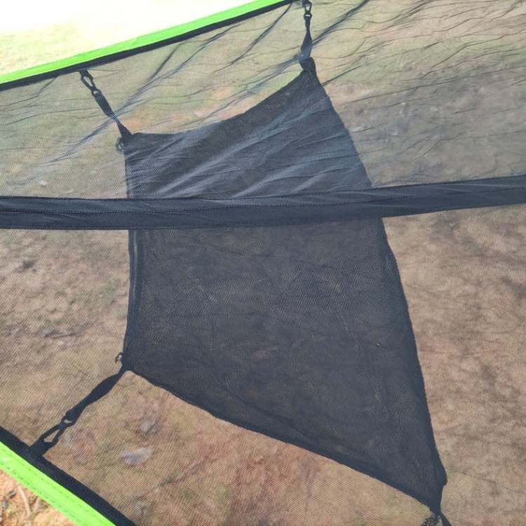 Triangle camping hammock installed between trees for outdoor relaxation