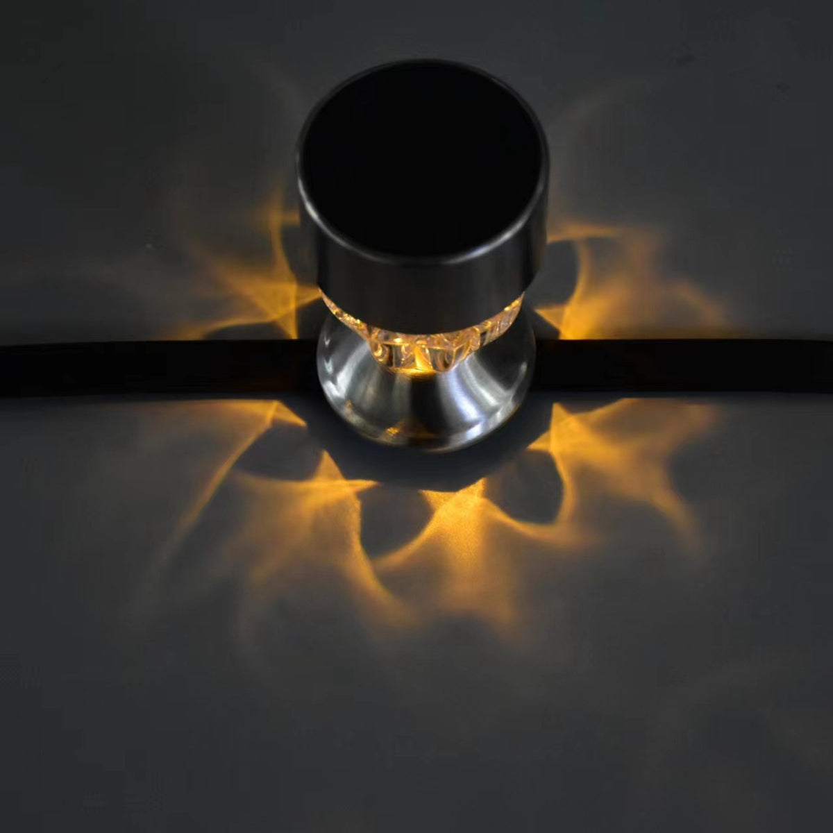 Warm white solar railing light casting decorative light patterns on a railing